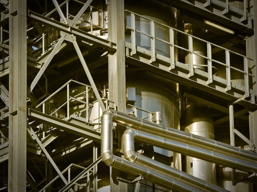 Constraint, not innovation, will decide which industries dominate the next decade Industrial infrastructure and factory towers at sunset, representing global industry constraints and economic dominance.